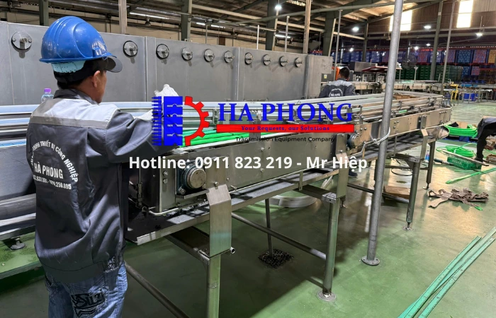 Kỹ thuật viên Hà Phong đang lắp đặt hệ thống cơ cong và thanh lót nhựa cho dây chuyền nước khoáng.